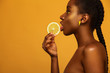 © Mike Orlov - Cheerful young african woman with yellow makeup on her eyes. Female model against yellow background with yellow lemons.