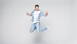 © F8  \ Suport Ukraine - Full-length photo of funny man in casual t-shirt and jeans running or jumping in air isolated over white background