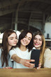 © Vadym - Three young women have fun and take selfie together