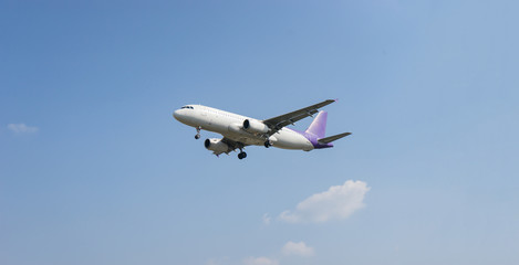 Passenger airplane concept,white airplane is flying in the blue sky with clouds over mountains, sea at colorful. Passengers aircraft is landing,Private jet plane. Travel