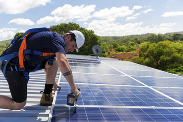 Wall Mural - Solar panel technician with drill installing solar panels