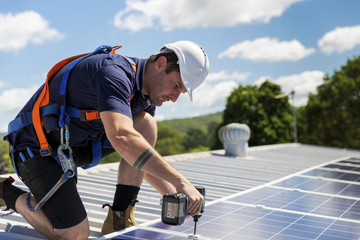 Wall Mural - Solar panel technician with drill installing solar panels