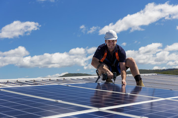 Wall Mural - Solar panel technician with drill installing solar panels