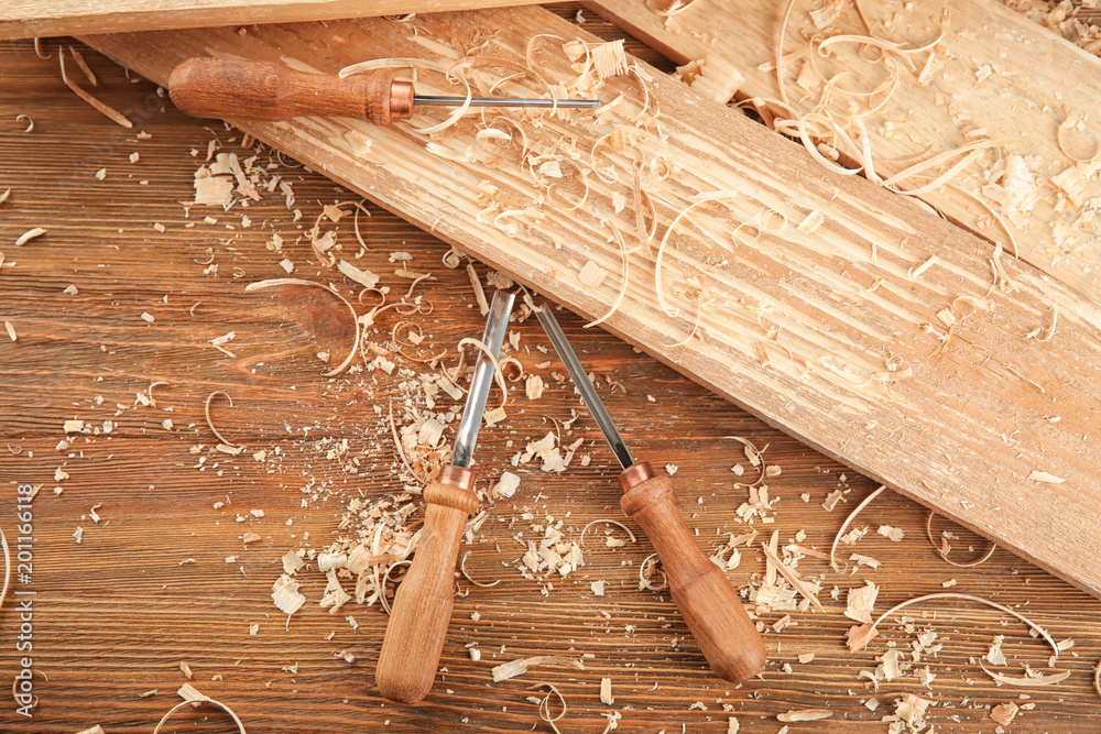 Chisels, wooden boards and sawdust in carpenter's workshop