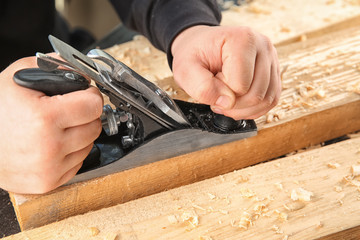 Canvas Print - Carpenter working with smoothing plane, closeup