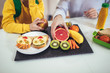 © Mediteraneo - Mother making breakfast for her children in the morning and a snack for school