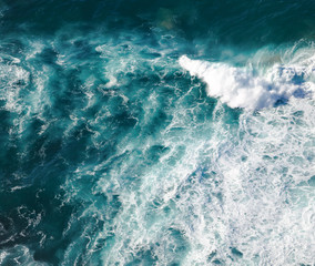 Turquoise seawater with foamy waves, picture from above, abstract ocean background and texture