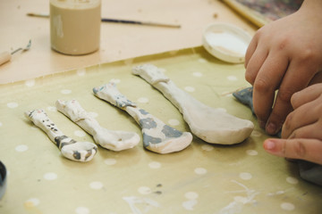 Wall Mural - Child sculpts the product from raw clay