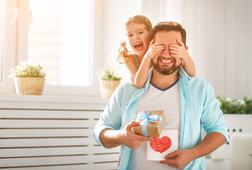 Wall Mural - father's day. happy family daughter hugging dad and laughs