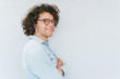 © iuricazac - Profile horizontal view portrait of handsome young male with curly hair, wearing denim blue shirt and round trendy spectacles, looking to the camera. Copy space for advertisement. People race concept.