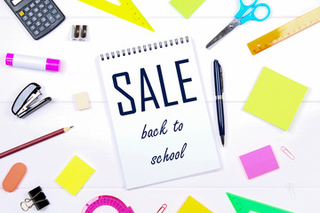 Wall Mural - A blank notebook page surrounded by stationery on a white wooden table. Back to school sale.