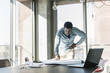 © Westend61 - Casual businessman working on plan at table in office