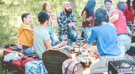 Happy friends having pic-nic meal with barbecue in nature outdoor