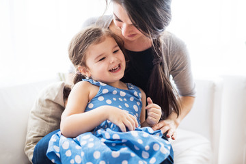 Wall Mural - Young mother with a small girl at home.