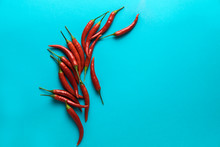 Group Of Little Red Hot Chili Peppers On The Blue Background.