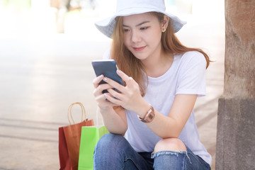 Cropped shot shopping girl using smartphone at holiday time.