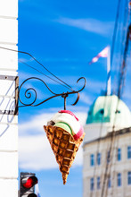 Big Plastic Ice Cream Cone Sign Over Blue Sky On City Street