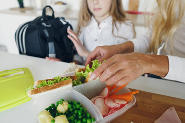 Mom preparing school snack lunch her daughter home kitchen