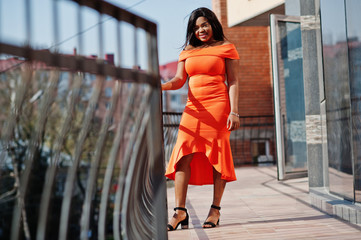 Wall Mural - African american woman model xxl in orange dress.