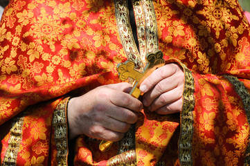 hands of priest holding cross, celebration of Orthodox Easter, traditional outdoor liturgy