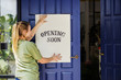 © Rawpixel.com - Woman putting on store opening soon sign