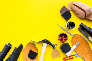 Wall Mural - Clobber tools. Hummer, awl, knife, sciccors, wooden shoe, paint and leather. Yellow background top view space for text