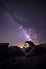 Lanscape view of the desert with stars and milky way galaxy over the night sky.  The image depicts astrophotography and nature.  