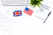 Learn english concept. British and american flags, computer keyboard, notebook for new vocabulary on white background top view copy space