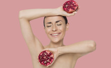 Bright And Emotional Beautiful Woman With Half A Pomegranate In Hands Posing In Front Of The Camera. Fruit Is Health.
