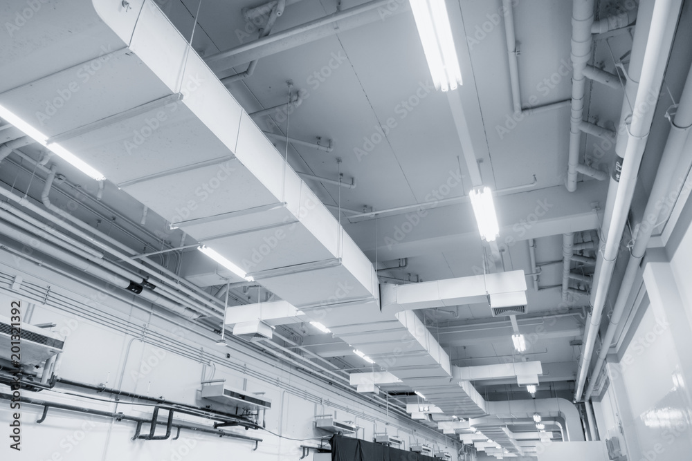 White Industrial Air duct from air conditioner cooling pipe with plumbing at ceiling in large industrial hall. - obrazy, fototapety, plakaty 