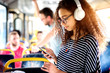 © dusanpetkovic1 - Young cheerful cute curly girl enjoying music while riding in the bus.