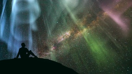 Wall Mural - The man sitting against the star shower with a northern light. time lapse