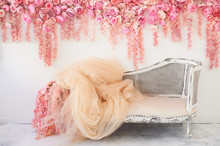 Old Carved Daybed With Soft Upholstery Against A White Wall Decorated With Pink Flowers. Gorgeous Garland. The Interior Decor Is Romantic, Wedding Photo Zone.