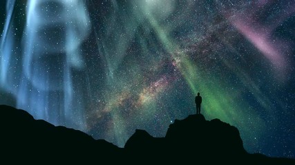 Wall Mural - The man standing on a mountain against a starry sky with a northern light