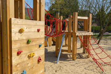 Sand with various wooden playground equipment on a public playground in Berlin