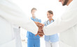 © ASDF - Doctors and nurses in a medical team stacking hands