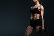 © LIGHTFIELD STUDIOS - cropped view of muscular sportswoman training with dumbbells, isolated on grey
