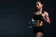 © LIGHTFIELD STUDIOS - beautiful muscular sportswoman with water in sport bottle, isolated on grey