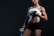© LIGHTFIELD STUDIOS - cropped view of sexy sportswoman with bottle of water showing abs, isolated on black