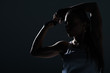 © LIGHTFIELD STUDIOS - silhouette of strong sportswoman showing muscular biceps, isolated on grey