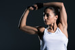 © LIGHTFIELD STUDIOS - strong sportswoman showing muscular biceps, isolated on grey