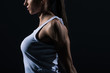 © LIGHTFIELD STUDIOS - cropped view of female bodybuilder stretching arms, isolated on black