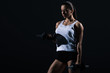 © LIGHTFIELD STUDIOS - beautiful young sportswoman lifting dumbbells, isolated on black