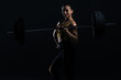 © LIGHTFIELD STUDIOS - beautiful female bodybuilder posing with barbell, isolated on black