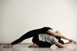 © New Africa - Young man and woman practicing yoga indoors