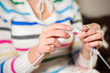 © nagaets - Close up of hands knitting. Process of knitting.