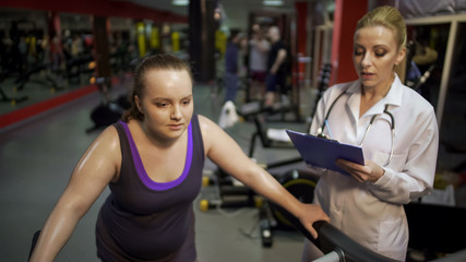 Female nutritionist consulting overweight woman on healthy diet for weight loss