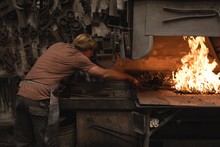 Blacksmith Heating Metal Rod In Fire