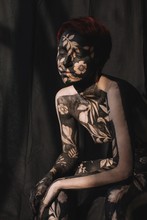 Portrait Of A Pensive Woman In Black And Gold Body Paint