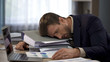 Depressed businessman lying on pile of folders, deadline pressure, exhaustion